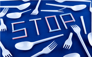 "STOP" spelled out with plastic straws surrounded by plastic forks and spoons